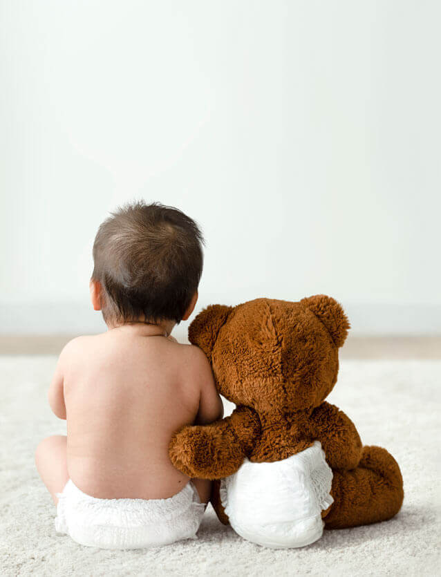 Bébé avec son doudou vu de dos