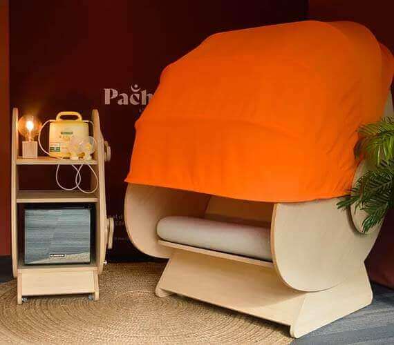 Image du fauteuil d'allaitement Pachamama avec sa canopé orange semi-fermée